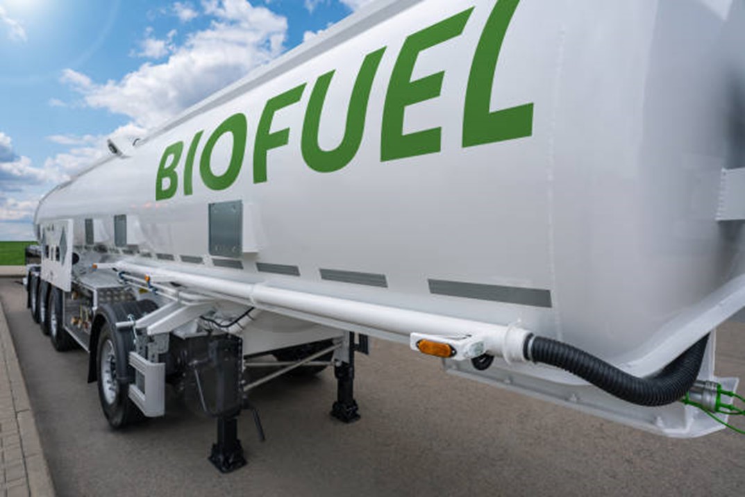 truck carrying huge cylinder with BIOFUEL printed on the side in green